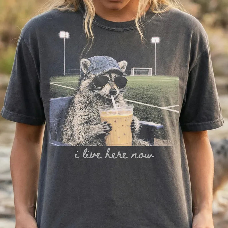 I Live Here Now Feral Raccoon Iced Coffee Shirt | Soccer Field Graphic Tee
